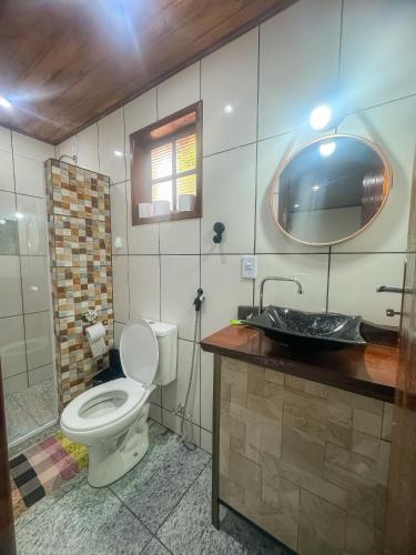 a bathroom with a toilet and a sink at Morada do Sabiá - chalé 1 in Resende