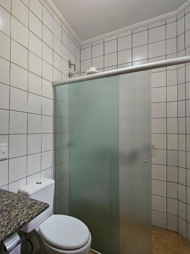 a bathroom with a toilet and a glass shower door at Pousada Siloé - Mosteiro de São Bento em Vinhedo in Vinhedo