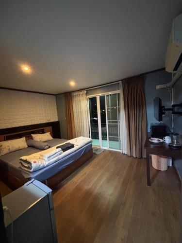 een slaapkamer met een bed en een groot raam bij Milos House in Ban Kata