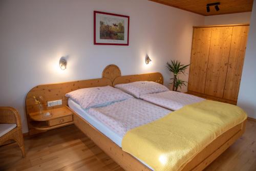 una camera da letto con un letto con testiera in legno di Haus Prodinger a Weisspriach