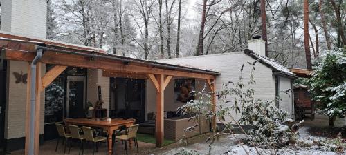 un patio con tavolo, sedie e una casa di Knabbel en Babbel a Lochem