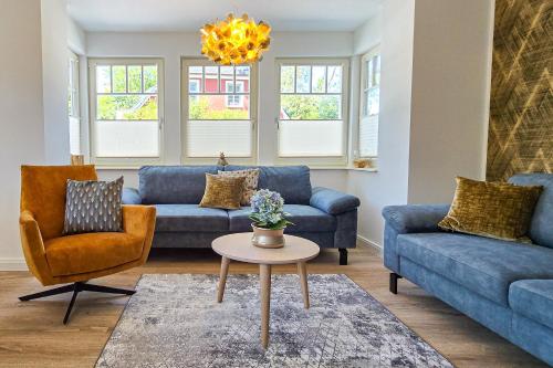 a living room with blue couches and a table at Darss Duett 2 in Prerow
