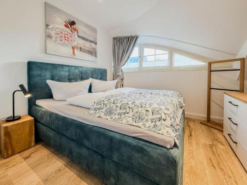 a bedroom with a bed with a blue headboard at Darss Duett 2 in Prerow