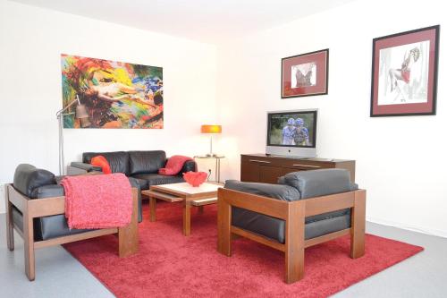 a living room with two couches and a tv at Ferienwohnung Malerwinkel in Seedorf