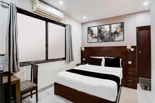 een slaapkamer met een groot bed en een raam bij Collection O Prem Nagar Dehradun Formerly Hotel Parjaat Residency in Dehradun