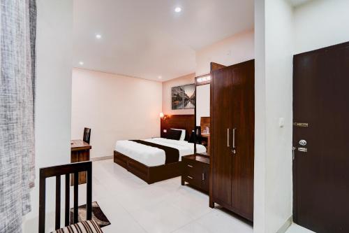 a hotel room with a bed and a bathroom at Super Collection O Prem Nagar Dehradun Formerly Hotel Parjaat Residency in Jhājra