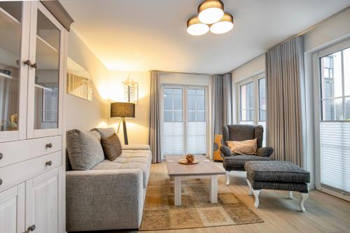 ein Wohnzimmer mit einer Couch und zwei Stühlen und einem Tisch in der Unterkunft Alte Fischfabrik Ruheinsel in Lauterbach