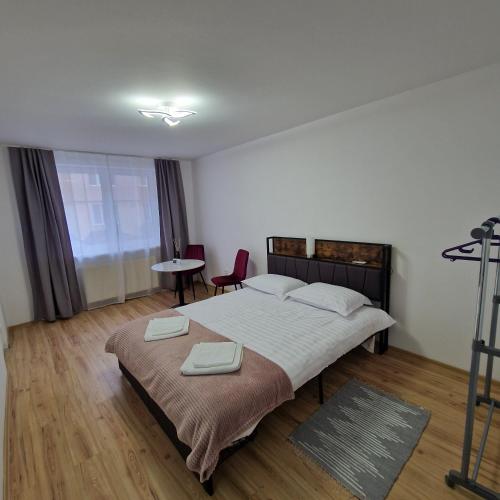 a bedroom with a bed and a table and a chair at Maria Central Studio in Târgu Neamț