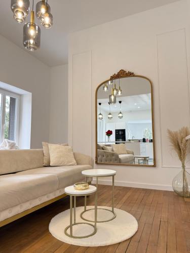 a living room with a couch and a mirror at Sublime logement neuf in Thaon-les-Vosges