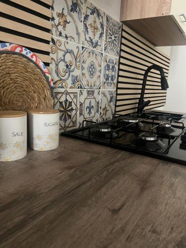 eine Küche mit einem Herd und einer Kachelwand in der Unterkunft Le Millesime du Soleil in Rosolini