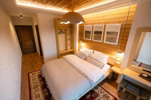 een slaapkamer met een groot wit bed en een bureau bij Chalet Village in Sohodol