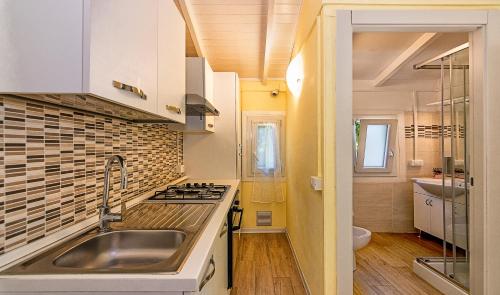 a kitchen with a sink and a stove top oven at Camping Parco Vacanza Partaccia 2 in Marina di Massa
