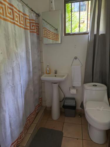 a bathroom with a sink and a toilet and a shower curtain at Studio apartment on the beach in Tamarindo