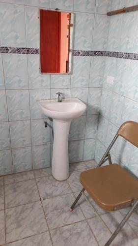 a bathroom with a sink and a mirror and a chair at Casa en arriendo in Quintero