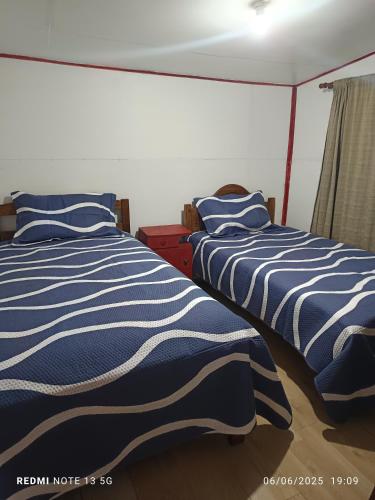 two beds sitting next to each other in a bedroom at Casa en arriendo in Quintero