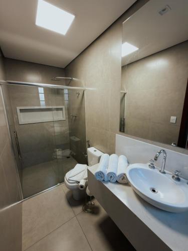 a bathroom with a sink and a toilet and a shower at Hotel Pousada Arcádia Mineira in Ouro Preto