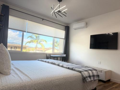una camera da letto con un letto e una finestra con una televisione di Waena Inn Unit 2 Newly Renovated Maui Private Suite a Wailuku