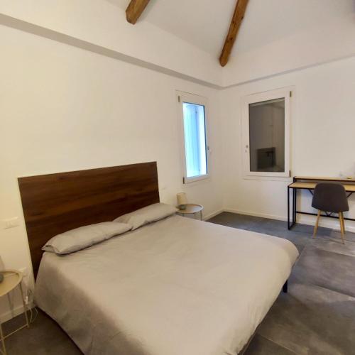 ein Schlafzimmer mit einem großen Bett und einem Schreibtisch in der Unterkunft De Uait Aus in Fossalta di Piave