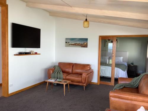 a living room with a couch and a tv and a bed at Ocean Breeze Holiday Home in Riverton