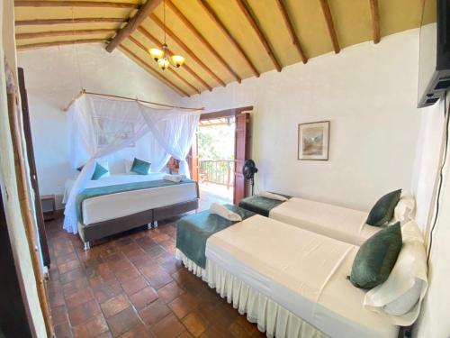 a bedroom with two beds and a window at Posada Sueños de Antonio in Barichara