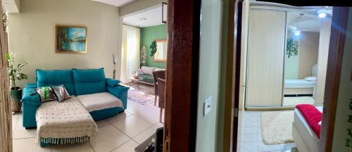 een woonkamer met een blauwe bank in een kamer bij Casa verde 4 quartos in Goiânia