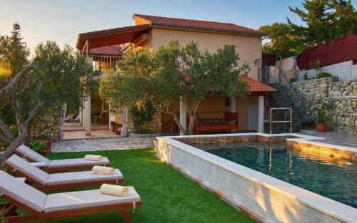 a backyard with a swimming pool and a house at Villa Serenity in Šibenik