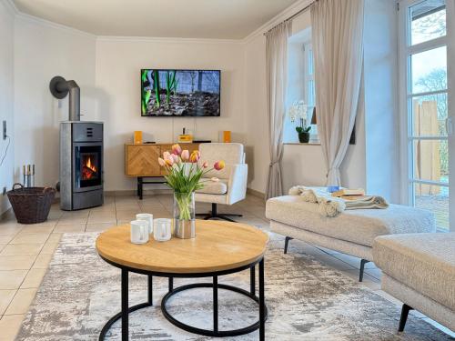 a living room with a table and a fireplace at Wellnessoase in Prerow