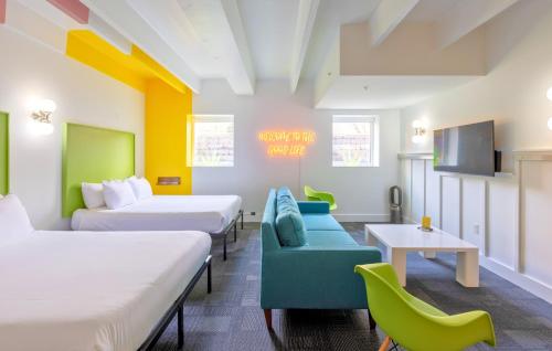 a room with two beds and a couch and a tv at The Gallatin in Nashville