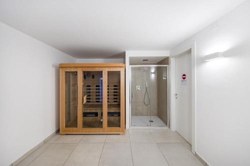 een kamer met een douche en een houten kast bij Villa Prestige in Sirmione