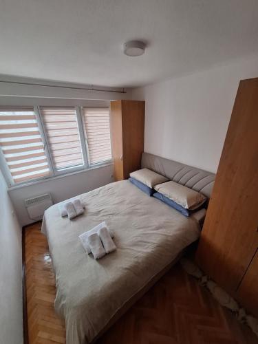 ein Schlafzimmer mit einem Bett und zwei Kissen darauf in der Unterkunft Apartman Mila in Bihać