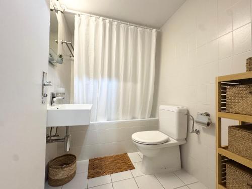 a white bathroom with a toilet and a sink at Bellavista Morgins in Troistorrents