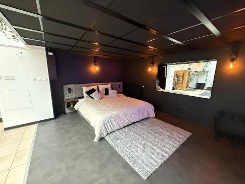 a bedroom with a large bed and a rug at Loft Des Sens in Saint-Chamond