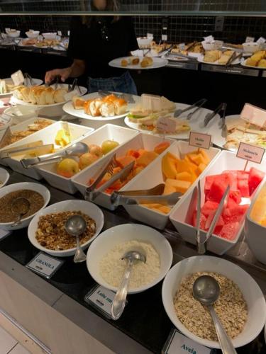 a buffet filled with different types of food with spoons at Baku Khatai Hotel & Restaurant in Baku