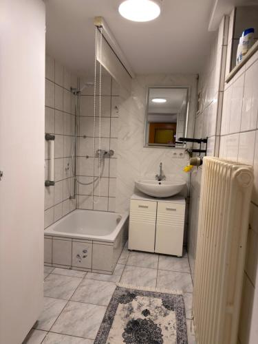 een badkamer met een douche, een wastafel en een bad bij Cozy apartment in Heiligenrode in Niestetal