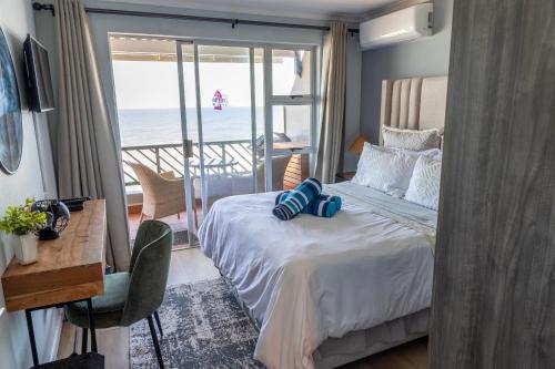 a bedroom with a bed with a view of the ocean at Dookes Apartment in Umdloti