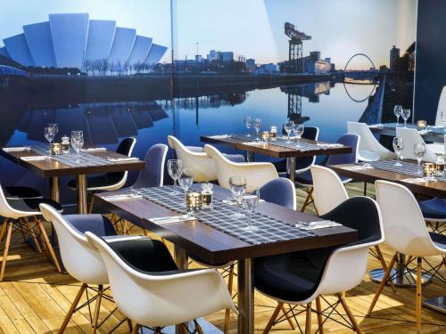a row of tables and chairs at a restaurant at ibis Glasgow City Centre – Sauchiehall St in Glasgow