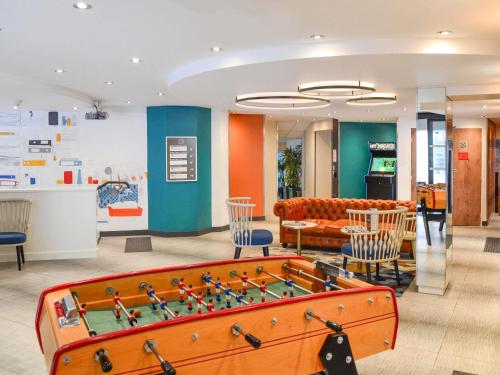 a living room with a pool table and chairs at ibis Paris Gare de Lyon Diderot in Paris