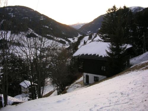 a house on a snow covered hill with mountains at Haus Framgard in Zirkitzen