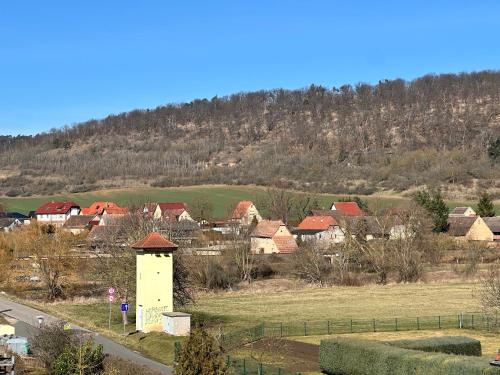 een klein dorpje met een heuvel op de achtergrond bij Himmelswege in Niederdorla