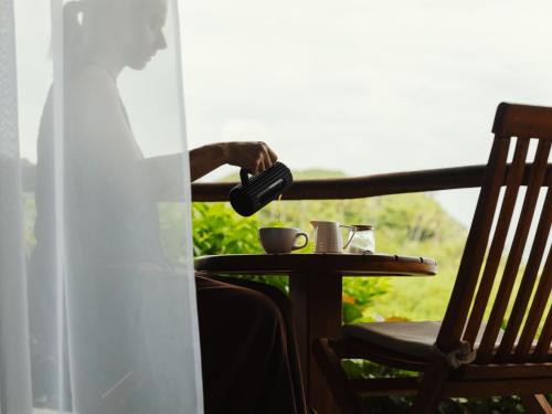 a man pouring a cup of coffee on a table at Finca Barlovento Maloka, Tayrona Park in Los Naranjos