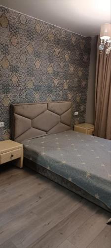 a bedroom with a bed and a wall at Aкварель на Черемушках in Odesa