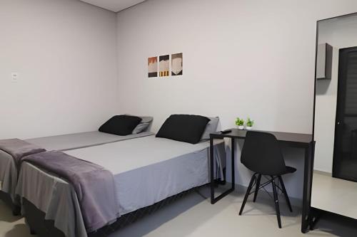 una camera da letto con un letto, una scrivania e una sedia di Studio I - Com Ar Condicionado a Jundiaí