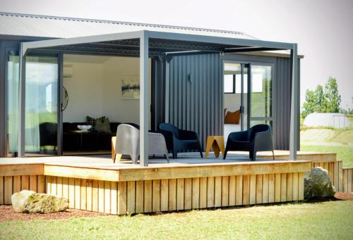a gazebo with chairs on a wooden deck at Tihi in Otorohanga