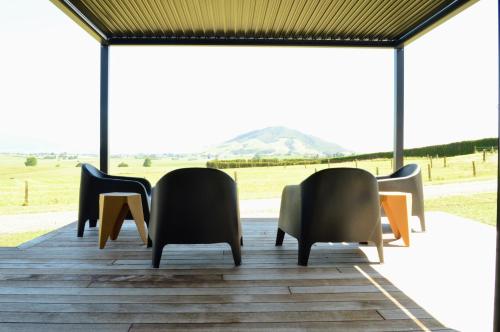 a group of chairs sitting on a deck with a view at Tihi in Otorohanga
