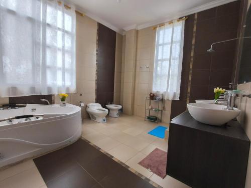 a bathroom with a tub and a sink and a toilet at Enchanted Haven in Puerto Baquerizo Moreno