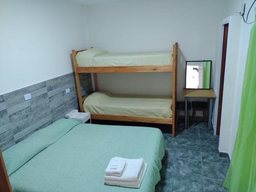 a small room with two bunk beds and a mirror at Hotel Riviera in Santa Teresita