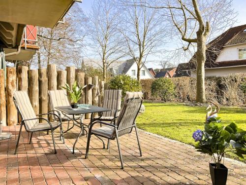 a patio with a table and chairs and a fence at Öresundhus 2 in Prerow