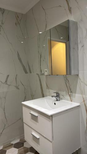 Duplex appartement في إتامب: حمام به حوض غسيل أبيض ومرآة