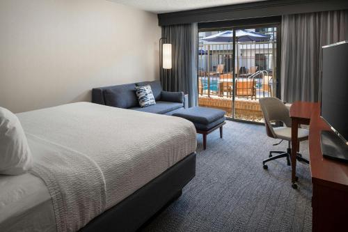 a hotel room with a bed and a chair and a desk at Courtyard Los Angeles Torrance/Palos Verdes in Torrance