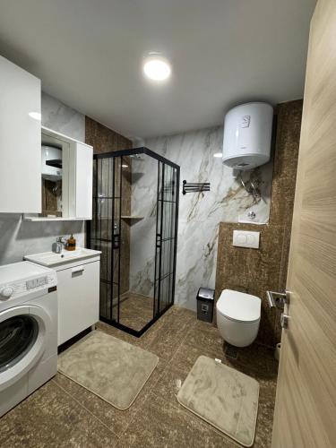 a bathroom with a washing machine and a toilet at Crown Apartmani Vlašić in Vlasic